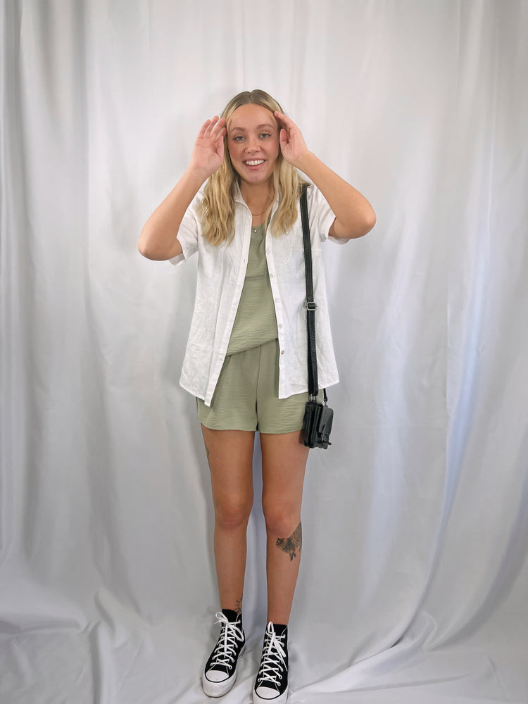 two piece set composed of lightweight woven fabric shapes a rounded neckline, wide tank straps top and a elasticized waist shorts in olive green or peach