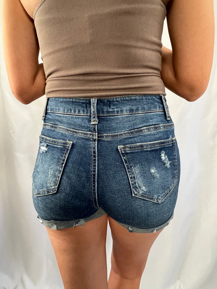 distressed cuffed blue denim shorts with raw hems pockets