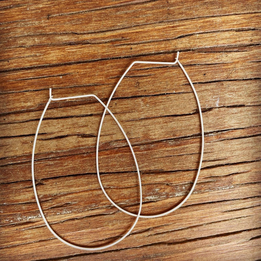 Dainty thin wire silver plated continuous hoop earrings for pierced ears.