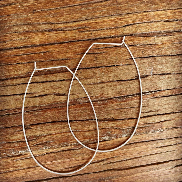 Dainty thin wire silver plated continuous hoop earrings for pierced ears.