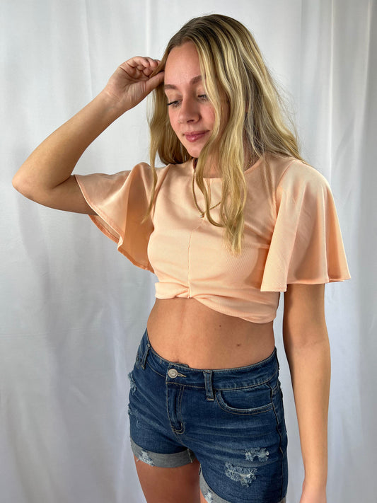 Light peach short draped sleeve crop top with twist front and round neck
