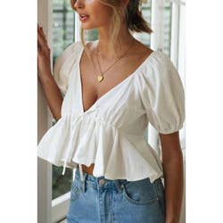 lightweight woven wide v-neckline top with tie detail puff short sleeves elastic shoulders cuffs a ruffled cropped hem open back